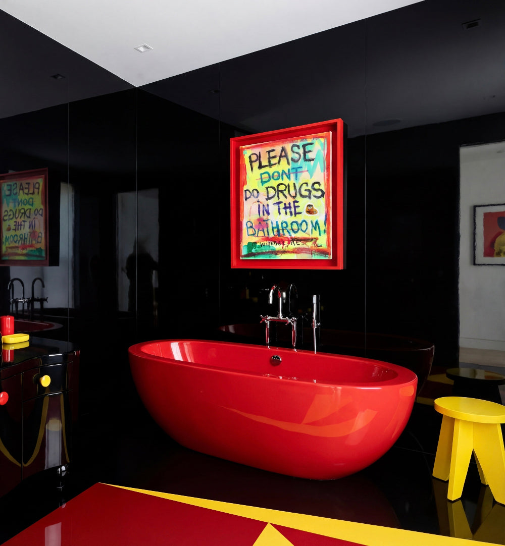 Modern bathroom with a red bathtub, colorful graffiti art, and a yellow stool.

